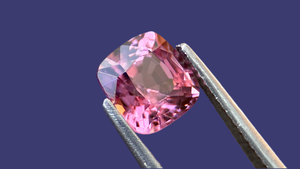 1ct vivid purple cushion-cut spinel gemstone, showcasing exceptional natural beauty and full traceability of origin. Set against a deep indigo blue background, perfect for bespoke jewellery lovers seeking ethical and unique gemstones.