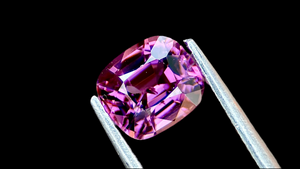 Bright transparent purple natural spinel gemstone, 1 carat showcasing on back background.