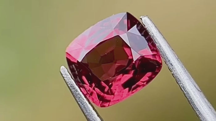 Pink brownish-red spinel gemstone, 1.53 carats, from Burma, cushion-cut and hand-cut, captured in natural daylight to showcase its rich colour and craftsmanship. Perfect for a custom jewellery centre stone or engagement ring.