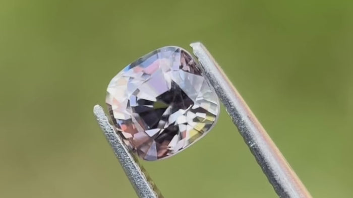 Natural untreated grey spinel gemstone from Myanmar, ideal engagement ring stone, shown in natural daylight with light green background.