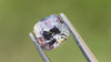 Natural untreated grey spinel gemstone from Myanmar, ideal engagement ring stone, shown in natural daylight with light green background.