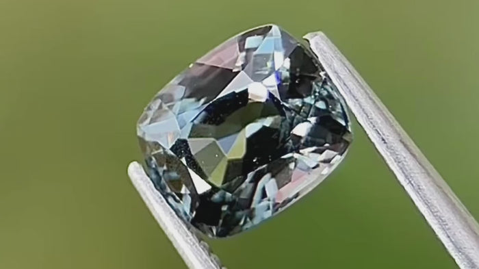 Cushion-cut teal green natural spinel from Mogok, dimensions 7x5.9x4.6mm, captured in natural daylight to highlight its rare colour and brilliance. Ideal for unique engagement rings and collectors.